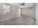 Bright bedroom featuring carpet flooring, neutral walls, ceiling fan, and two windows at 5752 N 109Th Ave, Phoenix, AZ 85037