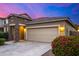 Home with a two-car garage, stone accents, and a blooming bush in the front yard at 5752 N 109Th Ave, Phoenix, AZ 85037