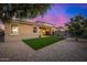 Charming home exterior with a cozy covered patio and artificial turf landscaping, set against a colorful evening sky at 5752 N 109Th Ave, Phoenix, AZ 85037