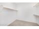 An empty walk-in closet with a rail for hanging clothes and neutral carpeting at 5752 N 109Th Ave, Phoenix, AZ 85037