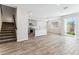 Bright open-concept living space with wood-look tile flooring and a view of the kitchen at 5828 E Covey Ln, Phoenix, AZ 85054