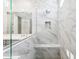 Luxurious shower featuring marble-look tile, a built-in bench, and modern fixtures for a spa-like experience at 5828 E Covey Ln, Phoenix, AZ 85054