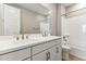 Bright bathroom featuring a double sink vanity, large mirror, and a bathtub with shower at 5856 E Covey Ln, Phoenix, AZ 85054