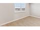 Neutral bedroom with wood-look tile flooring, white trim, and a bright, sunny window at 5856 E Covey Ln, Phoenix, AZ 85054