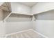 Walk-in closet featuring neutral carpeting and built-in shelving for ample storage at 5856 E Covey Ln, Phoenix, AZ 85054