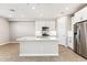 Well-lit kitchen featuring white cabinets, an island with a sink, and stainless steel appliances at 5856 E Covey Ln, Phoenix, AZ 85054