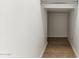 Hall walk-in closet with wood-look tile flooring and rod for hanging storage at 5856 E Covey Ln, Phoenix, AZ 85054