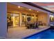 Outdoor living area with a covered patio, a dining set, and comfortable seating, perfect for enjoying the pool view at 644 E Las Puertas Ln, Queen Creek, AZ 85140
