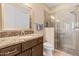 Bathroom showcasing a vanity with a granite top, a glass enclosed shower, and neutral tiling at 644 E Las Puertas Ln, Queen Creek, AZ 85140