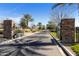 Gated community entrance with stone pillars and meticulously maintained landscaping at 644 E Las Puertas Ln, Queen Creek, AZ 85140