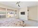 Bright main bedroom featuring plush carpet, ceiling fan, and multiple windows for ample natural light at 644 E Las Puertas Ln, Queen Creek, AZ 85140