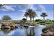 A community pond with flowing water and palm trees on a sunny day at 644 E Las Puertas Ln, Queen Creek, AZ 85140