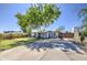 Home featuring a basketball hoop on the driveway, complemented by a lush front lawn and mature tree at 6728 N 24Th Dr, Phoenix, AZ 85015