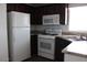 Clean kitchen with white appliances, dark wood cabinets, and durable countertops at 7807 E Main St # H7, Mesa, AZ 85207