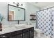 Bathroom featuring a white vessel sink, black vanity, and framed mirror at 9234 W Sierra Pinta Dr, Peoria, AZ 85382