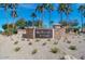 Westbrook Village entrance with stone signage surrounded by lush desert landscaping and tall palm trees under a clear blue sky at 9234 W Sierra Pinta Dr, Peoria, AZ 85382