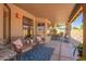 Charming covered patio features cozy seating and a stylish rug, great for relaxing outdoors at 9234 W Sierra Pinta Dr, Peoria, AZ 85382