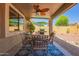 Outdoor dining area with a ceiling fan and barbeque for social gathering on the covered patio at 9234 W Sierra Pinta Dr, Peoria, AZ 85382