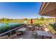 Outdoor patio with dining tables overlooks the beautiful golf course and pond with a fountain feature at 9234 W Sierra Pinta Dr, Peoria, AZ 85382