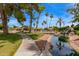 Tranquil community water feature with waterfalls, a pond, lush landscaping, and walking paths under a blue sky at 9234 W Sierra Pinta Dr, Peoria, AZ 85382