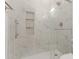 Modern bathroom features a glass enclosed shower, white marble tile, and built in shelves at 9518 W Hazelwood St, Phoenix, AZ 85037