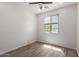Bright bedroom with hardwood floors, ceiling fan, and a window with natural light at 9518 W Hazelwood St, Phoenix, AZ 85037