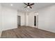 Spacious bedroom with wood-look flooring, ceiling fan, and ensuite bathroom access at 9518 W Hazelwood St, Phoenix, AZ 85037