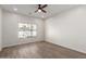 An empty bedroom boasts natural light, a ceiling fan, and wood-look flooring at 9518 W Hazelwood St, Phoenix, AZ 85037