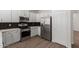 Bright kitchen featuring stainless steel appliances, white cabinetry, and modern backsplash at 9518 W Hazelwood St, Phoenix, AZ 85037