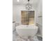 Luxurious bathroom features a modern soaking tub, unique window, and designer finishes at 10025 E Larkspur Dr, Scottsdale, AZ 85260