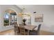 Elegant dining area with natural light, modern chandelier, and a view of outdoor greenery at 10025 E Larkspur Dr, Scottsdale, AZ 85260