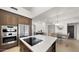 Open kitchen with stainless steel appliances, island with cooktop, wooden cabinets and eat-in dining area at 10025 E Larkspur Dr, Scottsdale, AZ 85260