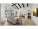 Bright living room features a beamed ceiling, large windows with outdoor views, and stylish furniture at 10025 E Larkspur Dr, Scottsdale, AZ 85260