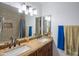 Bathroom featuring double sinks with granite countertop, stylish light fixtures, and a framed mirror at 102 E Angela Dr, Phoenix, AZ 85022