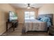 Bright bedroom with ceiling fan, wood-look floors, and a street view from the window at 102 E Angela Dr, Phoenix, AZ 85022