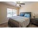 Cozy bedroom featuring a ceiling fan, neutral walls, and a window with natural light at 102 E Angela Dr, Phoenix, AZ 85022