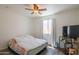 Bedroom showcasing a bed, window with curtains, and a ceiling fan, offering a cozy space at 102 E Angela Dr, Phoenix, AZ 85022