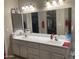 Bathroom featuring dual sinks, a large mirror, and storage below the vanity at 11360 E Keats Ave # 75, Mesa, AZ 85209