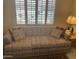 Cozy living room featuring a comfortable sofa and natural light from shuttered windows at 11360 E Keats Ave # 75, Mesa, AZ 85209