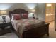 Main bedroom featuring a wood bed frame with a colorful quilt and bedside tables with lamps at 11360 E Keats Ave # 75, Mesa, AZ 85209