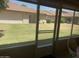 View from sunroom to the lawn and neighboring houses through a screened window at 11360 E Keats Ave # 75, Mesa, AZ 85209