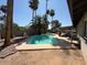 Green backyard with pool, tall palm trees, covered patio, and seating, perfect for relaxing at 12601 N 34Th St, Phoenix, AZ 85032