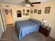 Bedroom with a ceiling fan, a small window, a nightstand, and several paintings at 12601 N 34Th St, Phoenix, AZ 85032