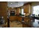 Galley kitchen with wooden cabinetry, granite countertops, and stainless appliances at 12601 N 34Th St, Phoenix, AZ 85032