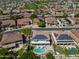 An aerial view shows a home with solar panels, a sparkling pool and backs onto a lush greenbelt at 13323 W Rancho Dr, Litchfield Park, AZ 85340