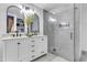 Bathroom featuring double vanity sinks, a large mirror, and a walk-in shower at 13323 W Rancho Dr, Litchfield Park, AZ 85340