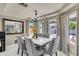 Dining area featuring a modern marble table, elegant chairs, chandelier, and ample light at 13323 W Rancho Dr, Litchfield Park, AZ 85340