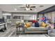 A bright and airy living room features wood flooring, a ceiling fan, and a comfortable sofa with throw pillows at 13323 W Rancho Dr, Litchfield Park, AZ 85340