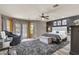 Spacious main bedroom with a tufted headboard, wood floors, and views of the pool through large windows at 13323 W Rancho Dr, Litchfield Park, AZ 85340
