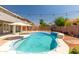 Backyard pool with a sun umbrella and lush landscaping at 13323 W Rancho Dr, Litchfield Park, AZ 85340